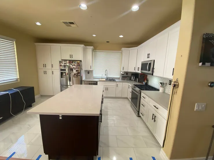 Modern kitchen renovation with dark cabinets and marble island